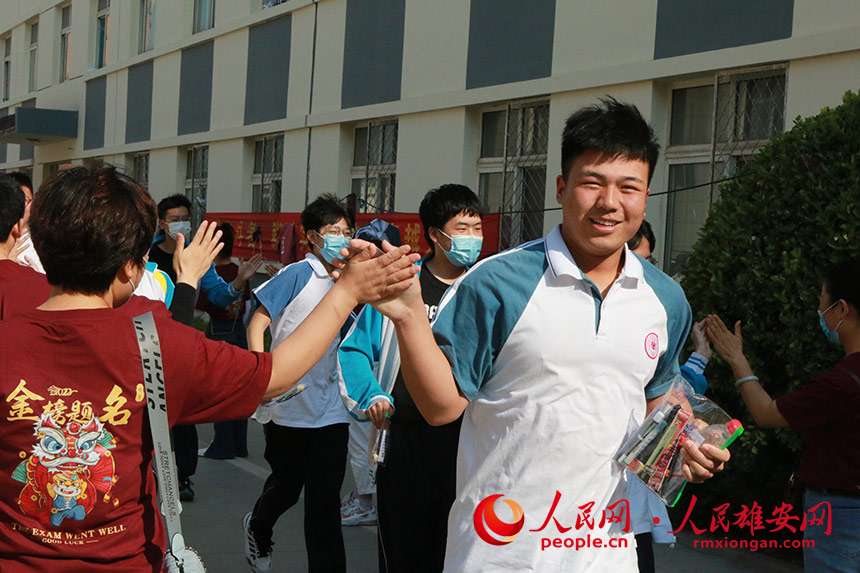 安新中學(xué)的考生進(jìn)場(chǎng)前與老師擊掌鼓勁。人民網(wǎng) 劉師豪攝