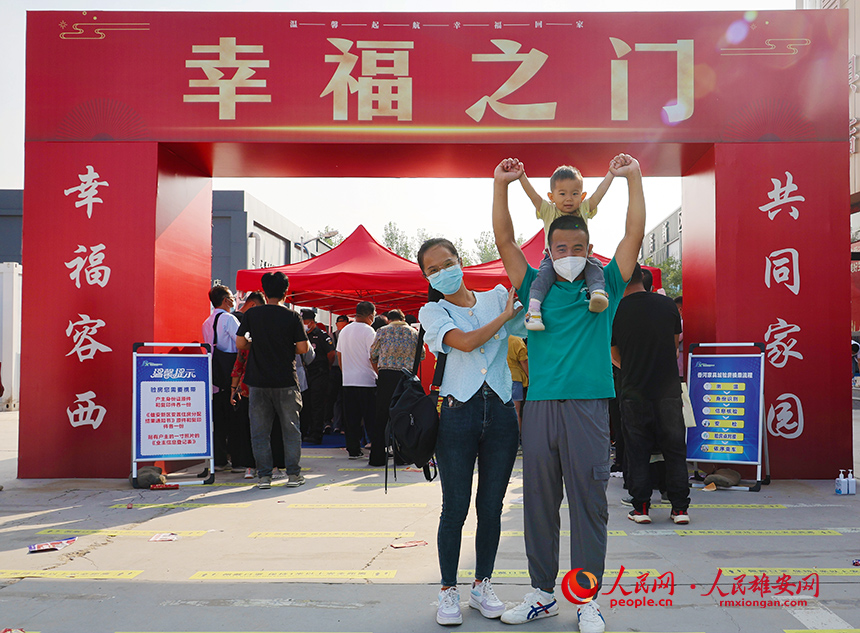 回遷群眾一家三口在“幸福之門”前合影。齊鑫攝