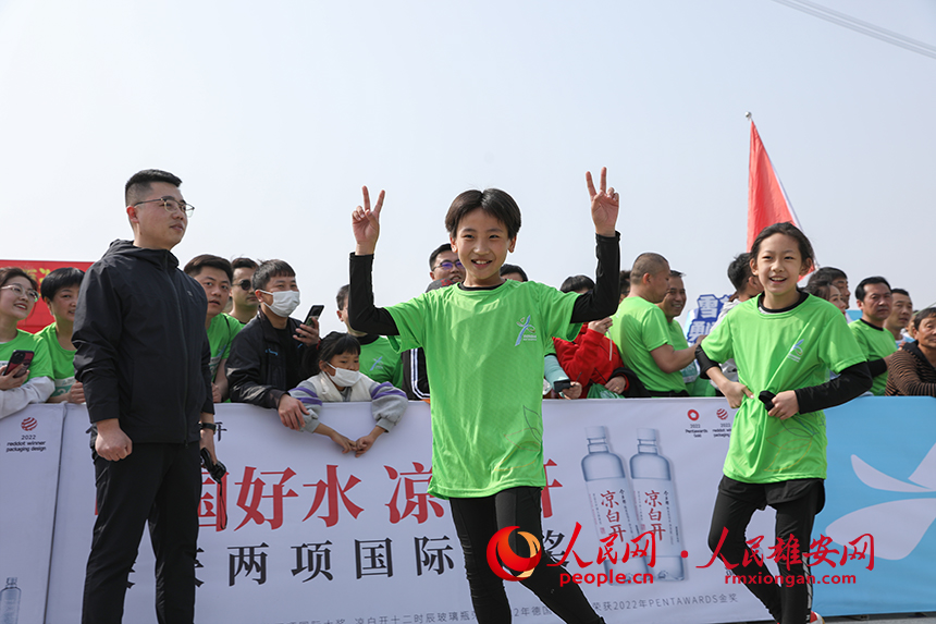 2023雄安半程馬拉松現(xiàn)場，完成健康跑的小選手正在慶祝勝利。人民網(wǎng) 李兆民攝