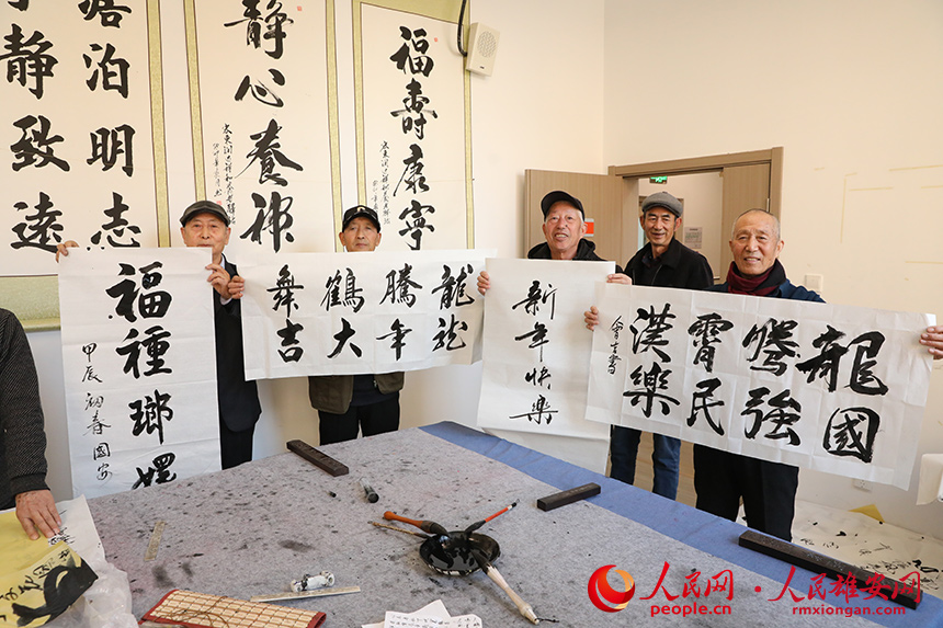 老人們展示自己的書(shū)法作品。人民網(wǎng)記者 王紅攝