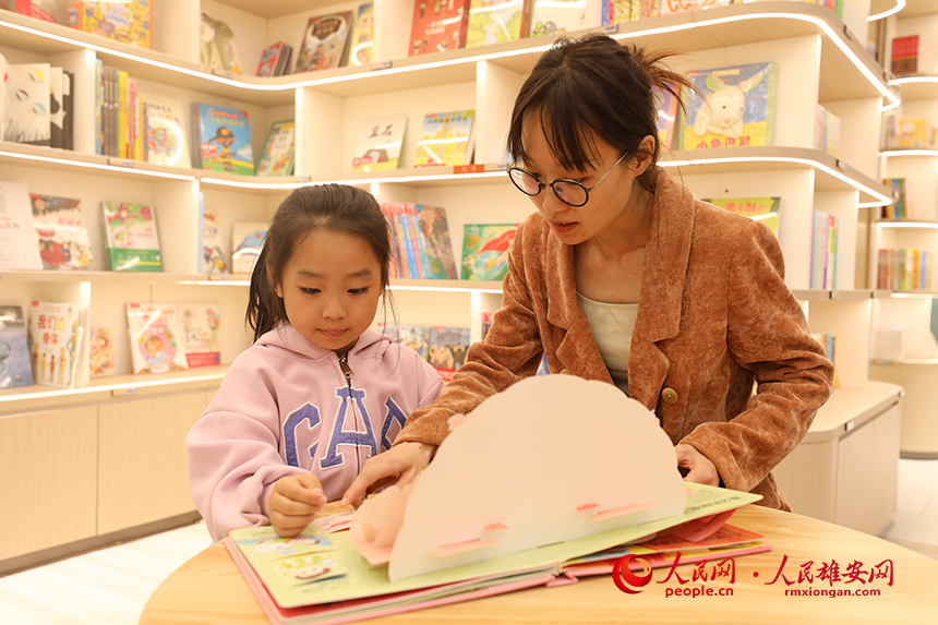 4月22日，在雄安新區新建片區的書店里，一名家長正在陪孩子閱讀。人民網記者 李兆民攝
