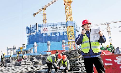 1月20日，雄安城際站及國貿中心項目建設現場，中國五冶集團雄安國貿中心項目常務副指揮長黃紹平(右一）正在進行巡查。本報記者 劉光昱攝